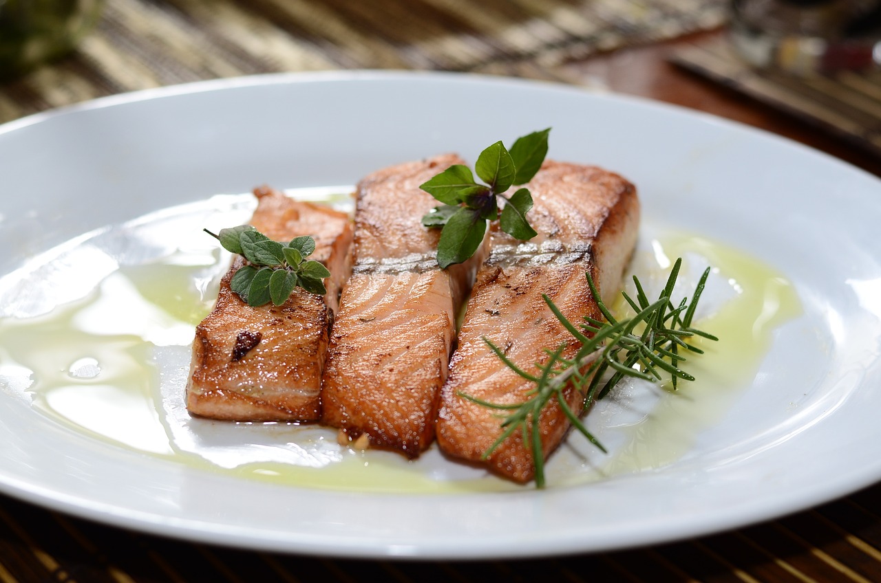 plate of cooked salmon dressed with herbs